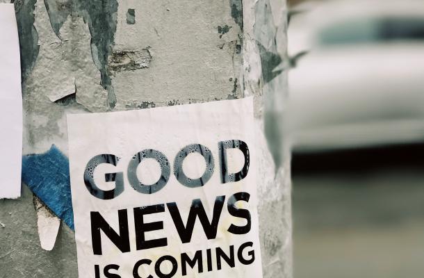A flyer pasted to a telephone pole reads "Good news is coming"