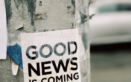 A flyer pasted to a telephone pole reads "Good news is coming"
